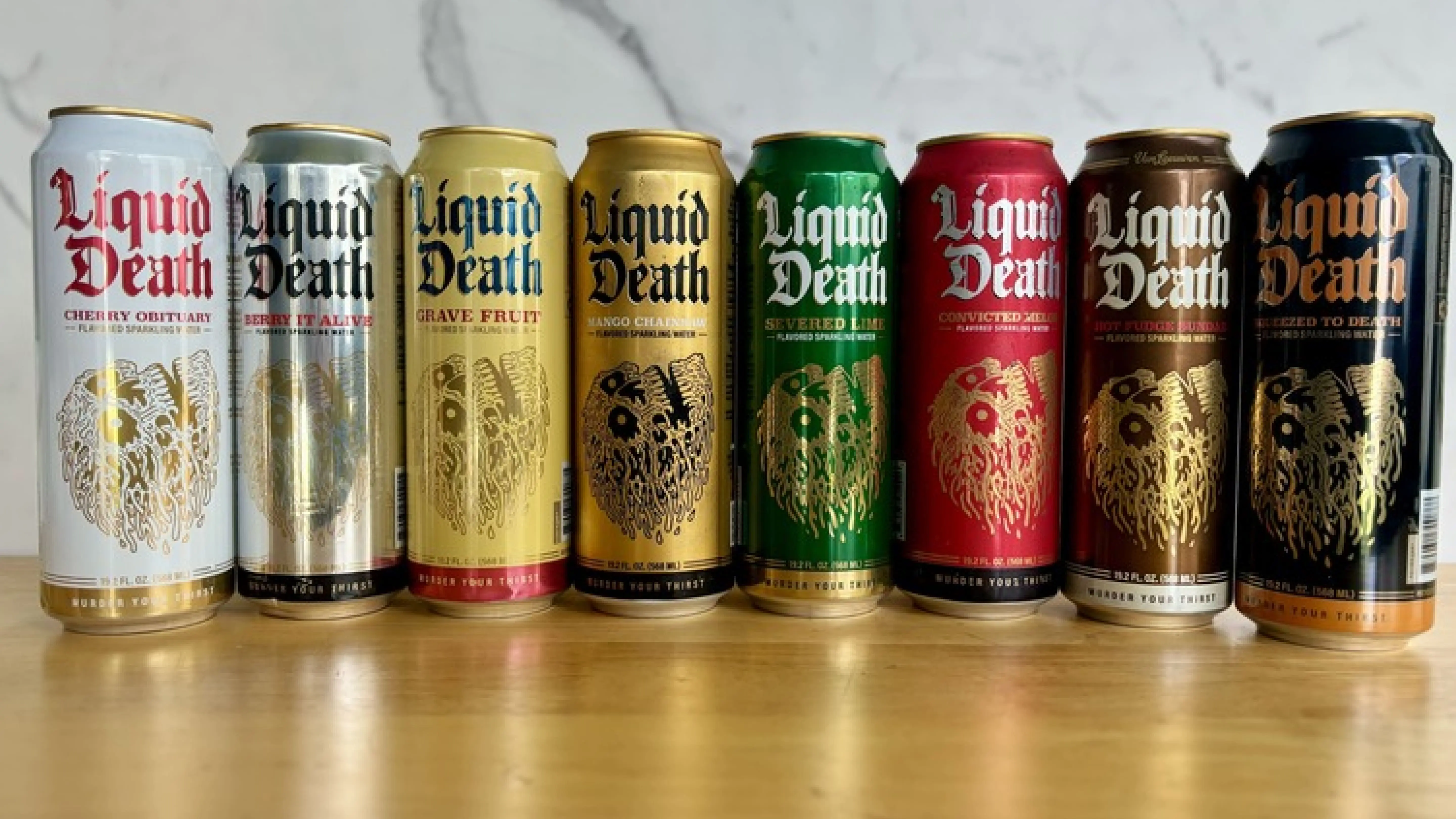 Eight different flavors of Liquid Death sparkling water, including Cherry Obituary, Berry It Alive, Mango Chainsaw, Severed Lime, and Convicted Melon.