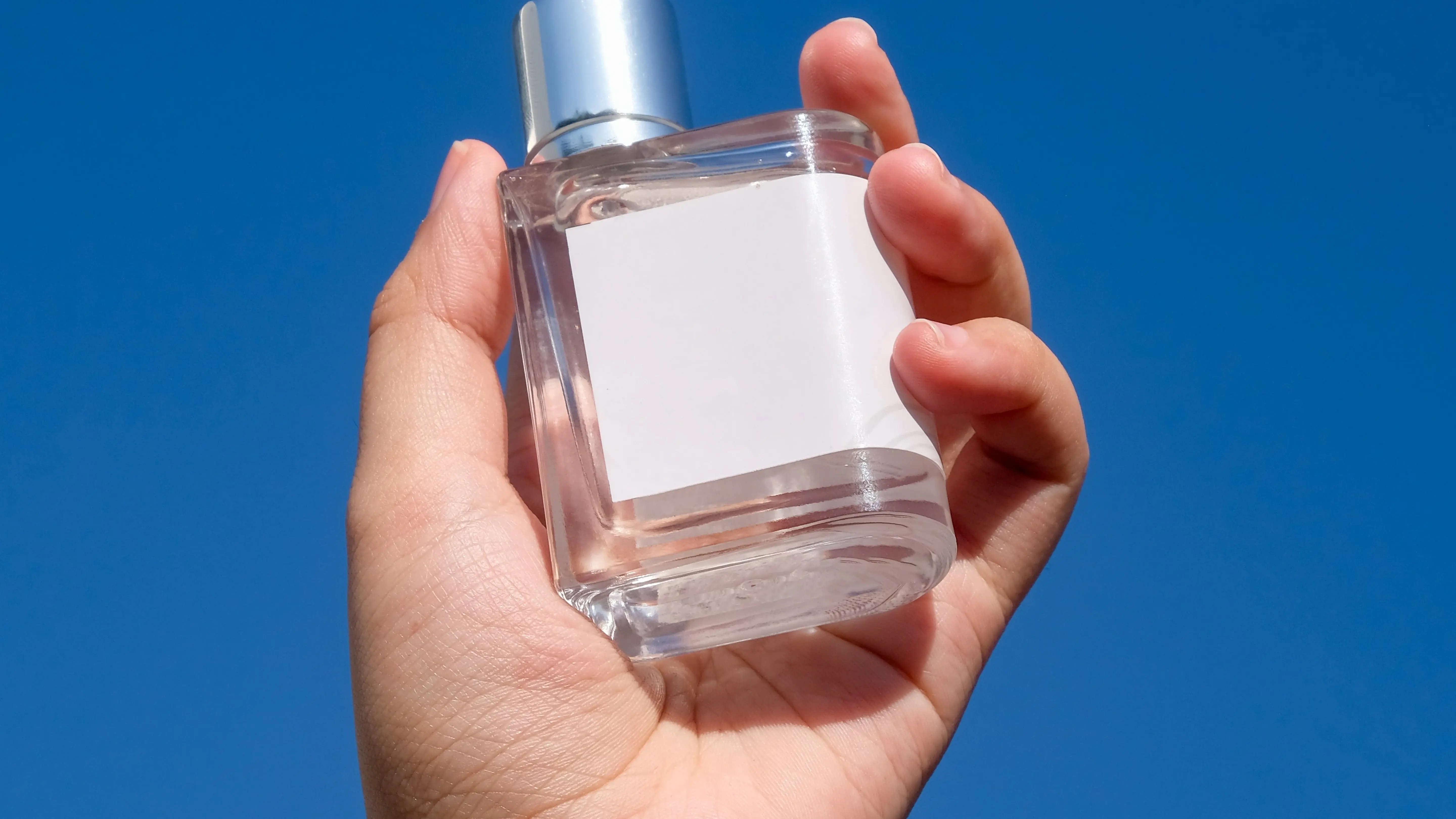 An unlabelled perfume hold by hand.